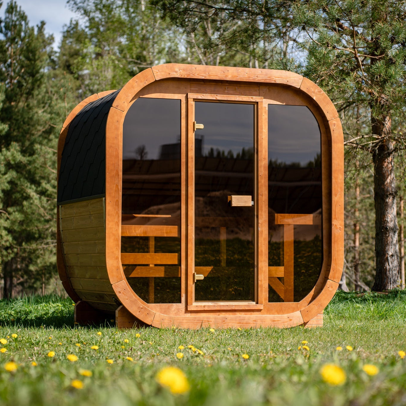 Sauna ogrodowa SAUNARI G160 w formie kubika stojąca na tarasie w ogrodzie